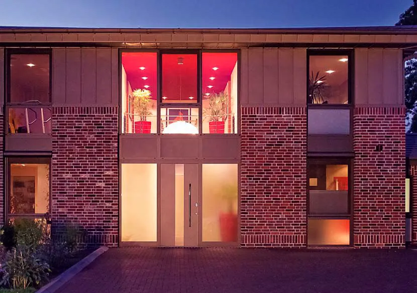 maison moderne avec grandes baies vitrées et porte d'entrée design