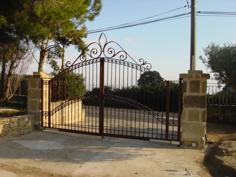 Entrée d'une propriété avec portail en fer forgé noir